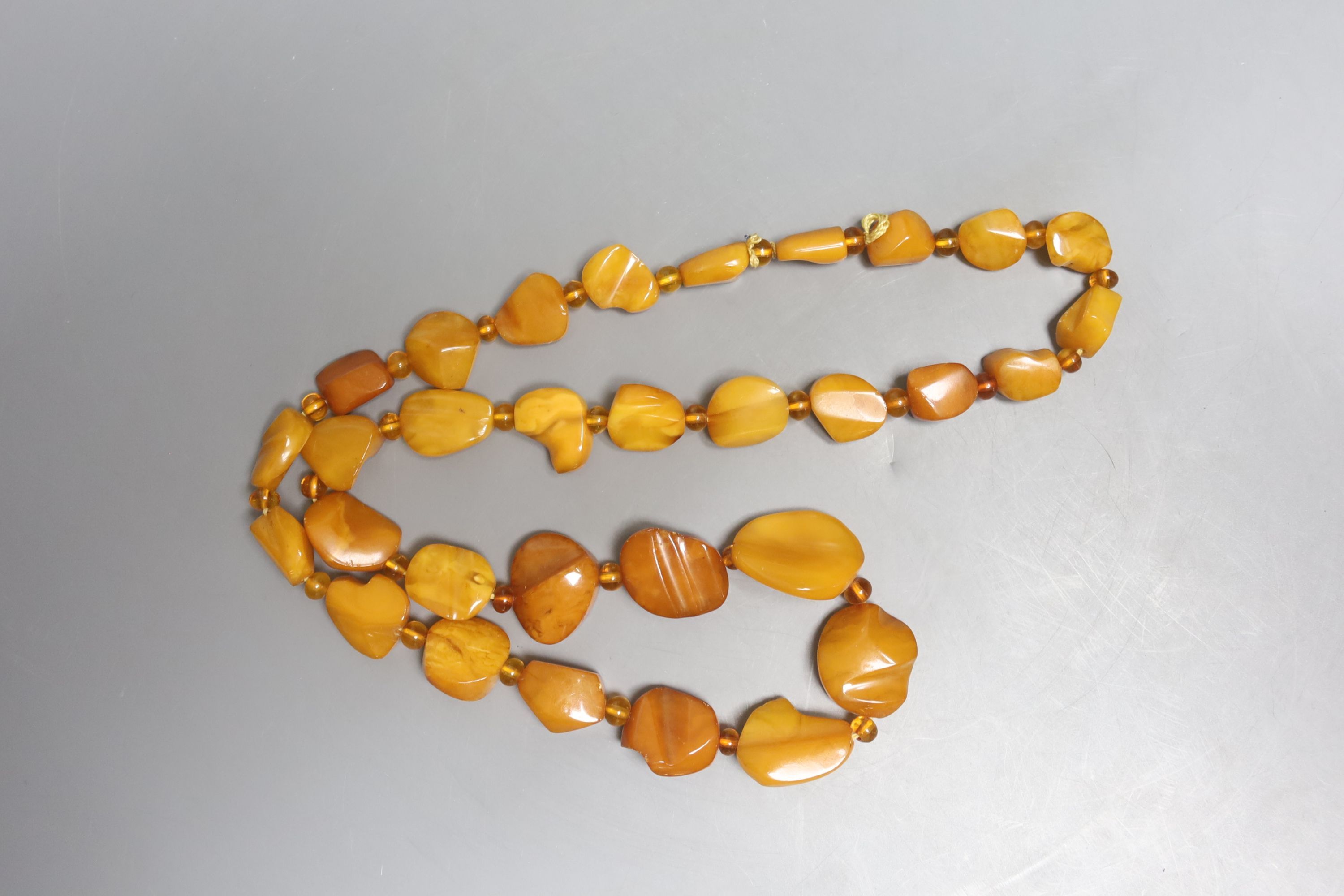 A single strand graduated amber pebble necklace, with amber bead spacers, 82cm, gross 84 grams.